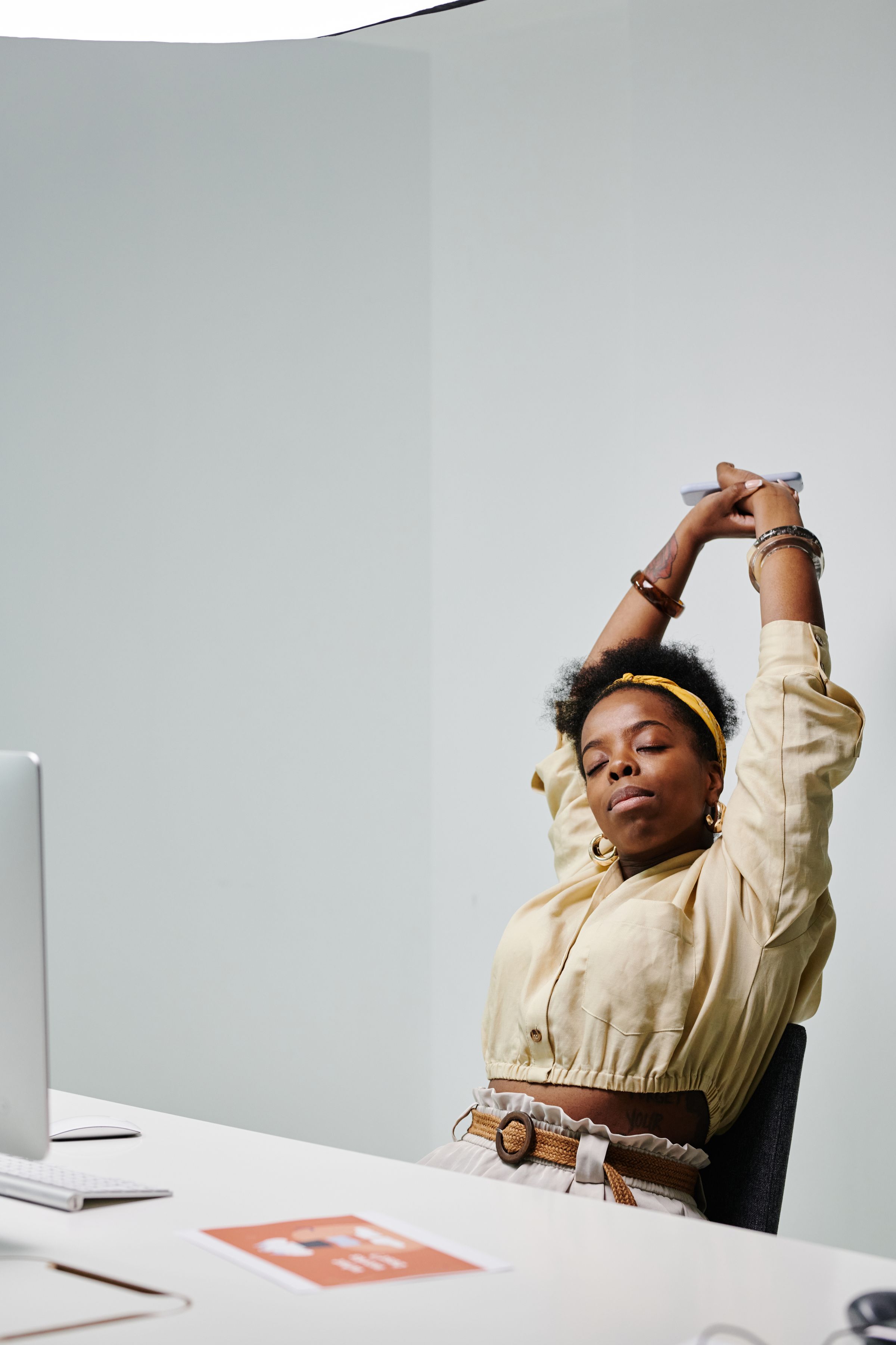 An office worker stretching at her desk between tasks