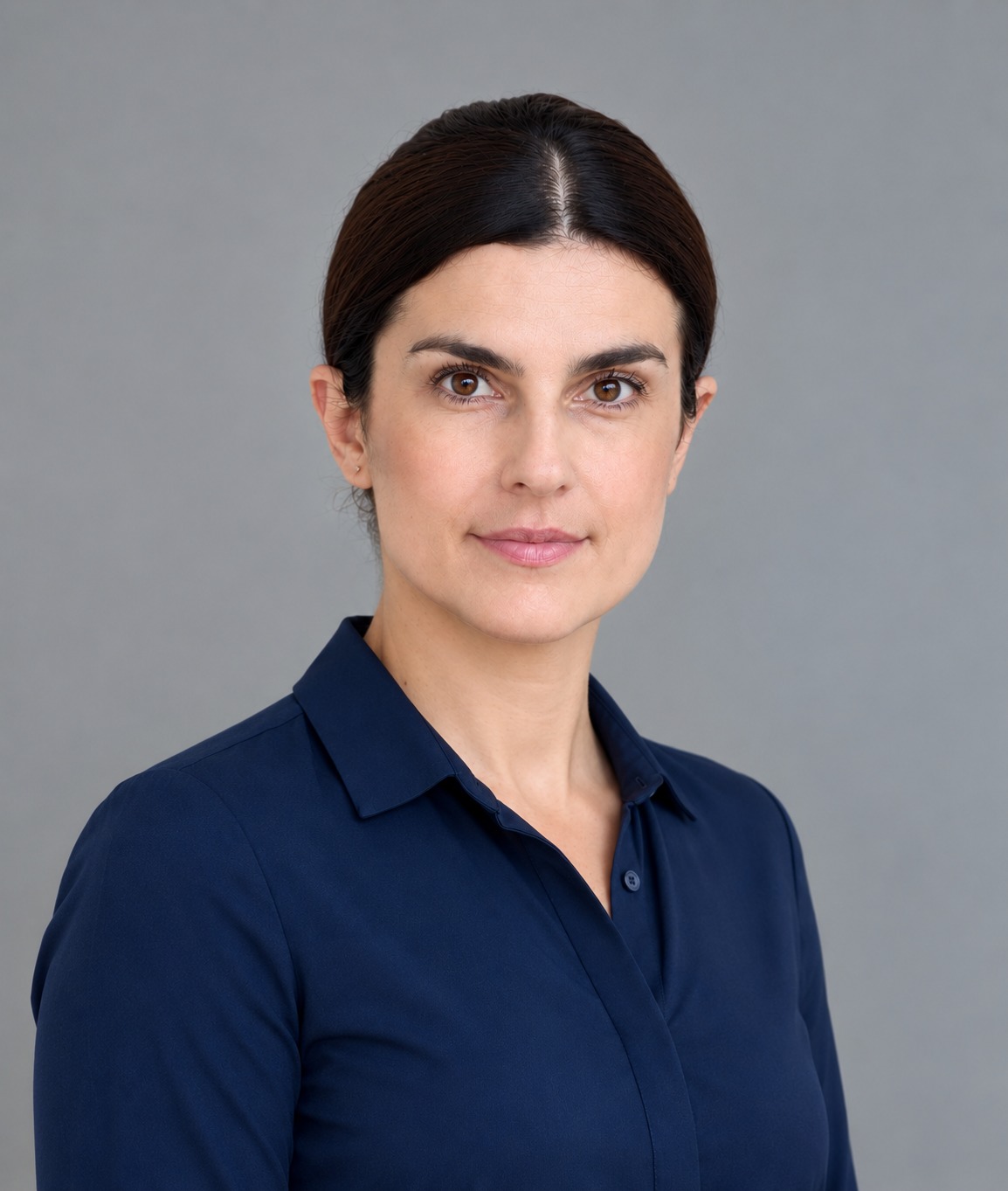 Ella Samuel, Co-Founder and Chief Clinical Officer of Kinemetry, photographed against a neutral grey background.